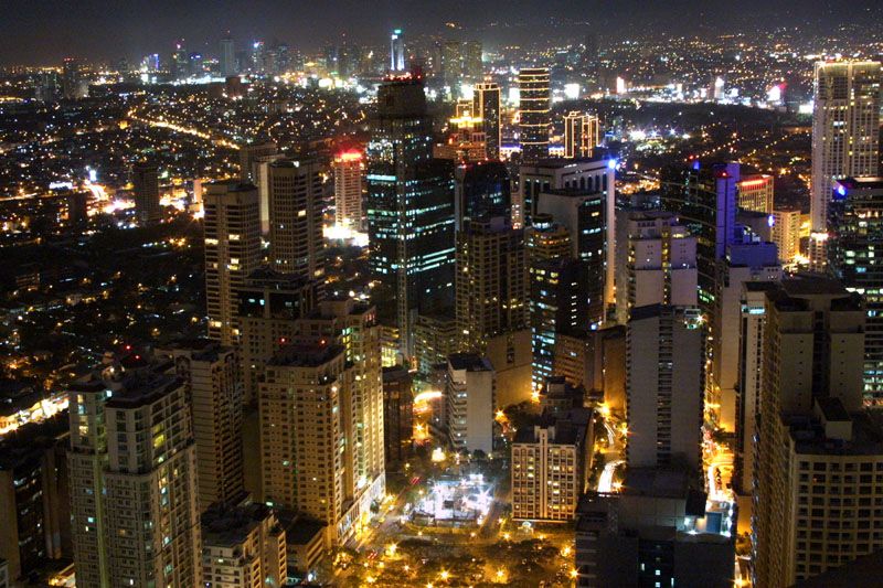 Nighttime city skyline of dense skyscrapers with orange and deep blue tones